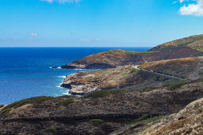 Scenic view of sea and mountains against blue sky