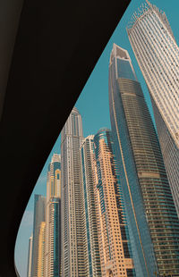 Low angle view of bridge against modern buildings