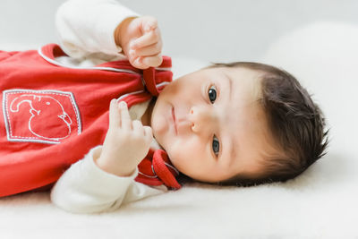 Close-up of cute baby lying on bed