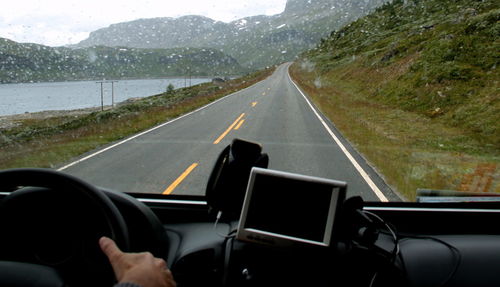 Close-up of man driving car on road