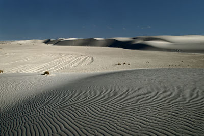 Sand dunes in desert against sky