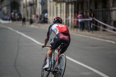 Rear view of man riding bicycle on road