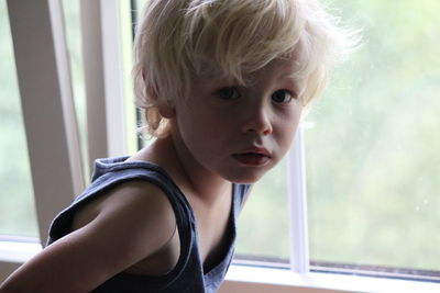 Portrait of boy standing by window