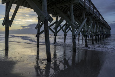 Pier on sea against sky at sunset