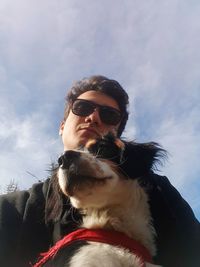 Portrait of man with dog against sky