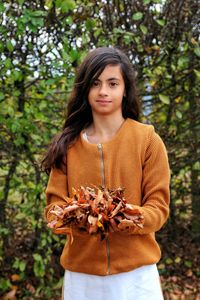 Portrait of woman standing against tree