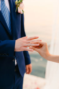 Midsection of couple holding hands