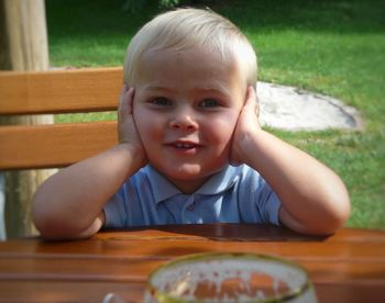 Portrait of cute boy sitting on table