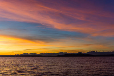 Scenic view of sea against dramatic sky during sunset