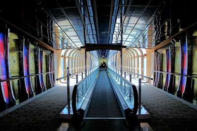 Take the moving walkway through the enclosed ramp to the club. dance the night away disco neon.