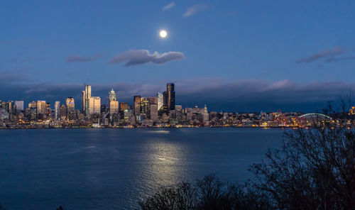 A bright full moon shines over the seattle skyline.