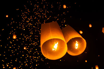 Low angle view of illuminated lantern against sky at night