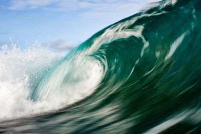 Aerial view of sea waves against sky