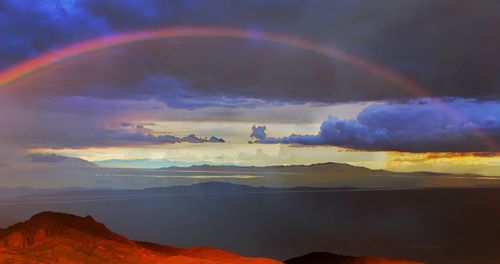 Scenic view of rainbow over landscape against sky