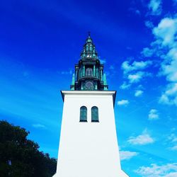 Low angle view of bell tower against blue sky