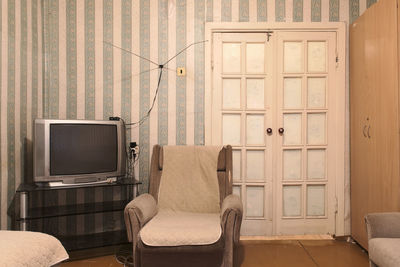 Example of old soviet russian poor interior in khruschev house. aged tv, chairs, sofa.