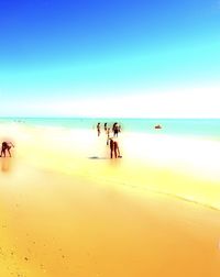 People at beach against sky