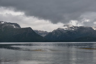 Scenic view of mountains and lake against cloudy sky