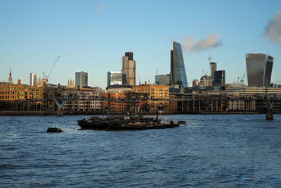 Scenic view of river by city of london against sky