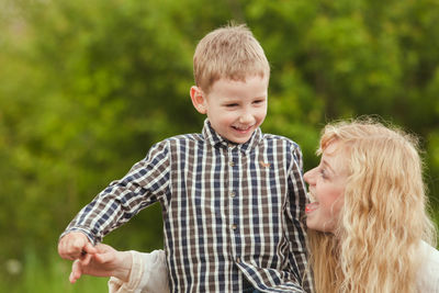 Smiling mother and daughter while standing outdoors