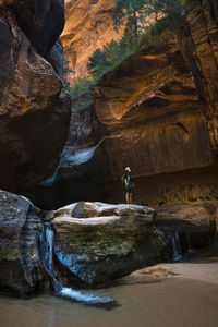 Hiker standing on rock formation in zion national park