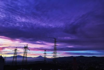 Power lines against cloudy sky