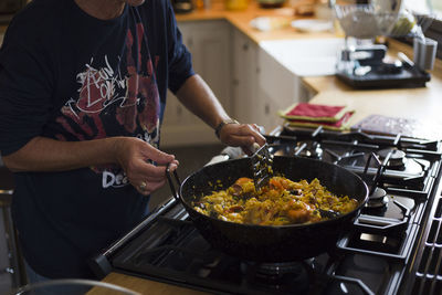 Midsection of man preparing food in kitchen