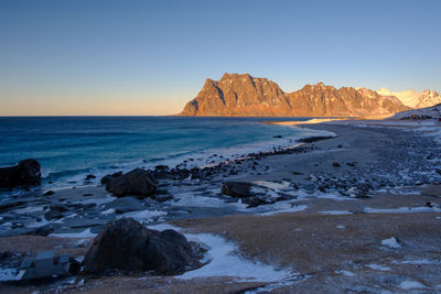 Scenic view of rock formation in sea against clear sky