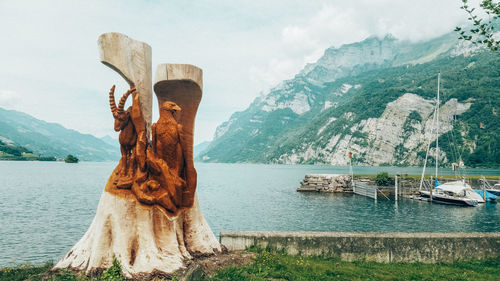 Reflection of man in lake against mountain range
