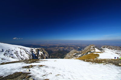 Scenic view of snowcapped mountains against clear blue sky