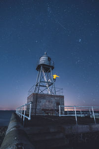 Man standing on lookout tower against sky at night