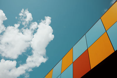 Colored tiles on wall against blue sky