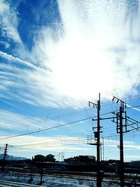Low angle view of electricity pylon against blue sky