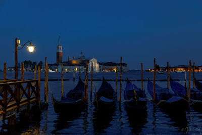 Boats moored in canal at dusk