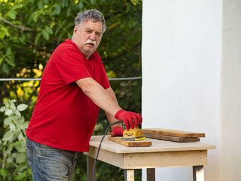 Man holding umbrella while standing in yard