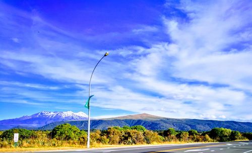Road by mountains against blue sky