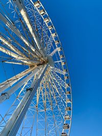 Low angle view of ferris wheel against blue sky