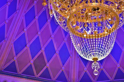 Low angle view of illuminated light bulbs hanging from ceiling