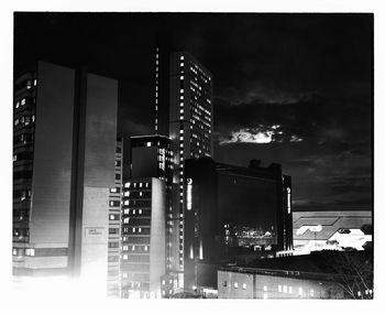 Illuminated city against sky at night