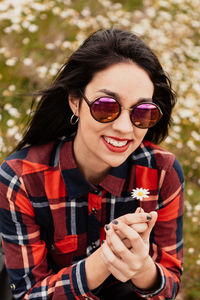 Portrait of smiling young woman wearing sunglasses