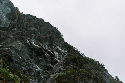 Low angle view of rocky mountain against sky