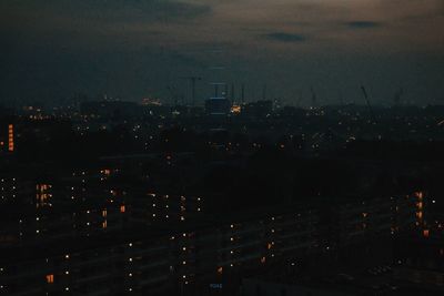 Illuminated cityscape against sky at night