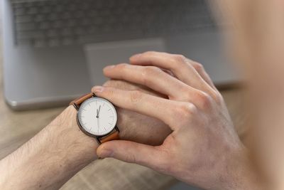 Cropped hand of person holding pocket watch