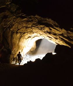 Silhouette man standing in cave