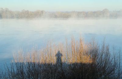 Scenic view of lake against sky during winter