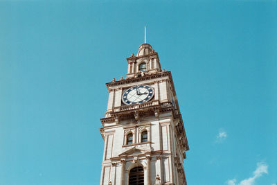 Low angle view of clock tower against blue sky