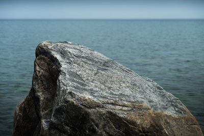 Rock formation in sea against sky