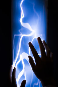 Close-up of hand on illuminated light