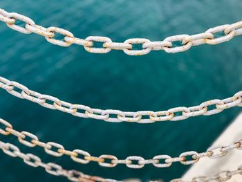 Close-up of rusty chain against sea