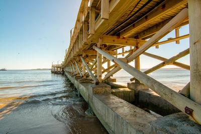 View of pier on beach against clear sky